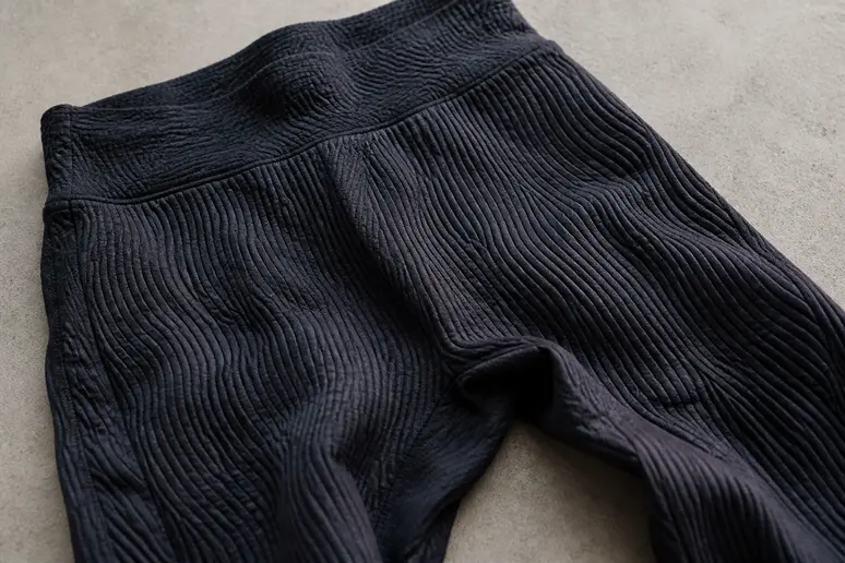 Gros plan sur le tissu texturé du legging Ceralia 3D, posé à plat sur une surface neutre, mettant en évidence sa densité.