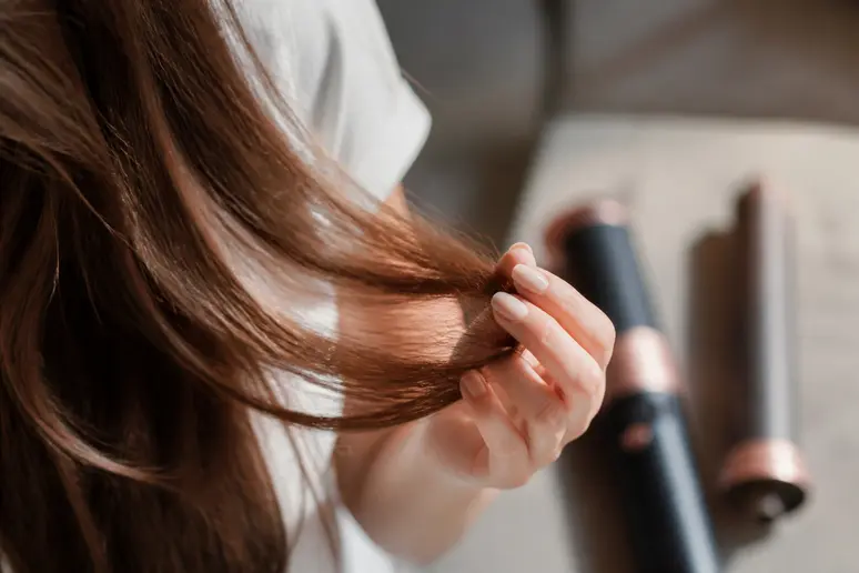 Gros plan sur une mèche de cheveux sains, évoquant l'impact du dyson airwrap avis negatif sur la fibre capillaire.