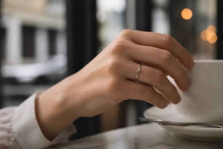 Main féminine portant une bague zag minimaliste en argent avec un charmant croissant de lune.