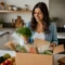 Une femme déballe un carton de livraison rempli de légumes frais dans sa cuisine pour se faire un avis hello fresh