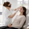 Une dermatologue examine attentivement les sourcils d'une cliente avant une séance de détatouage sourcils en cabinet.