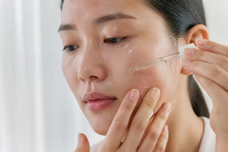 Application d'un sérum fluide pour respecter l'ordre idéal d'une routine visage minimaliste.