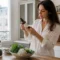 Une femme analyse les étiquettes pour savoir comment choisir produits bio dans sa cuisine lumineuse