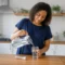 Femme préparant une boisson pour tester les Hydratis bienfaits énergie récupération dans sa cuisine
