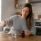 Femme préparant un verre d'eau le matin avec des compléments alimentaires dans sa cuisine pour Joia Minceur avis