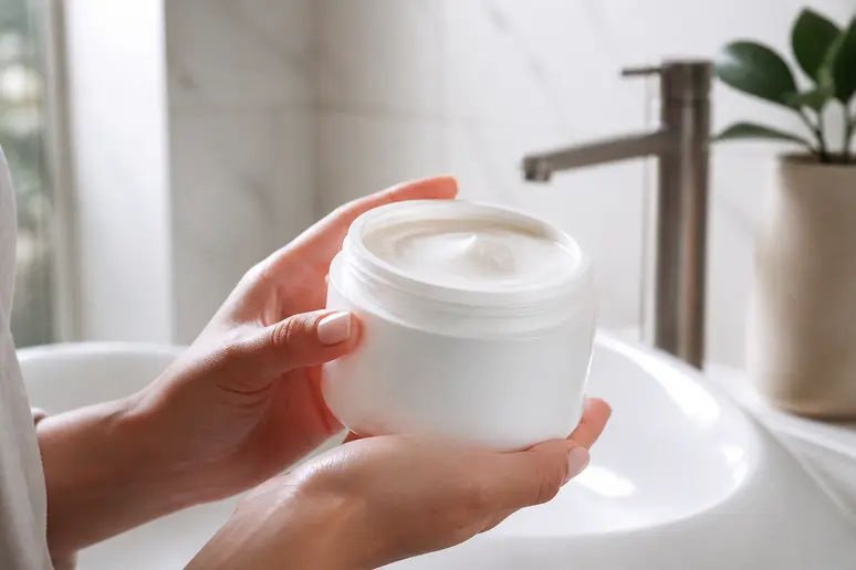 Mains appliquant un soin capillaire Lazartigue pour cheveux abîmés