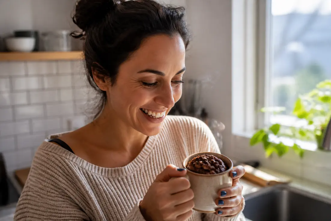Dégustation d'un délicieux mug cake cookie parfait fait maison dans une cuisine lumineuse.
