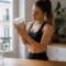 Femme examinant un pot de poudre dans sa cuisine pour savoir comment choisir compléments sportifs sans additifs