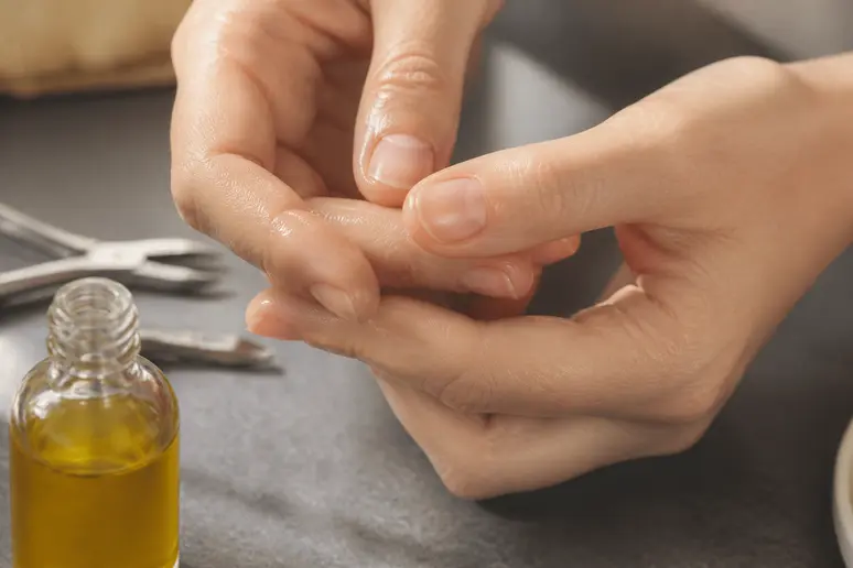 Massage des cuticules avec une huile végétale nourrissante pour soigner les ongles après la dépose