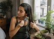 Une femme applique un masque naturel sur ses mèches pour éclaircir cheveux naturellement avant après dans son salon lumineux.