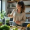 Jeune femme préparant un smoothie vert dans sa cuisine lumineuse pour un glow up naturel au quotidien