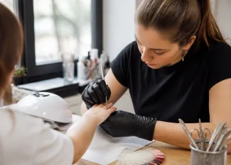 Gros plan sur les mains lors d'une manucure russe en salon de beauté avec des instruments professionnels.