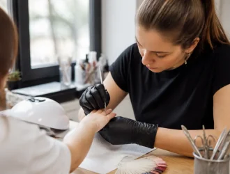 Gros plan sur les mains lors d'une manucure russe en salon de beauté avec des instruments professionnels.