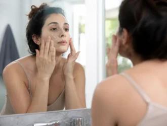 Femme appliquant un soin du visage devant son miroir pour un masque medicube avis