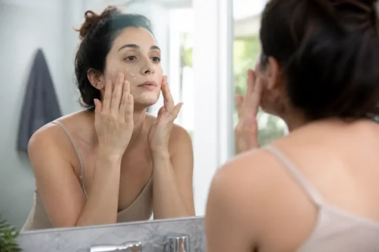 Femme appliquant un soin du visage devant son miroir pour un masque medicube avis
