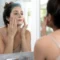 Femme appliquant un soin du visage devant son miroir pour un masque medicube avis