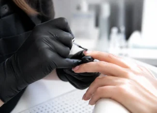 Gros plan sur une manucure montrant comment appliquer primer ongle avec précision sans toucher les cuticules.